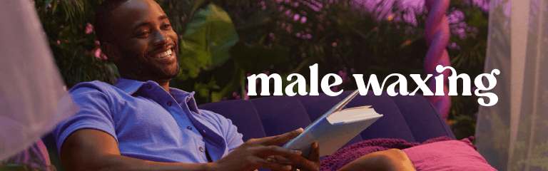 Male waxing in white text against superimposed over an image of an African American male smiling wearing a denim top with a collar while holding a hardcover book in a room with greenery and curtains