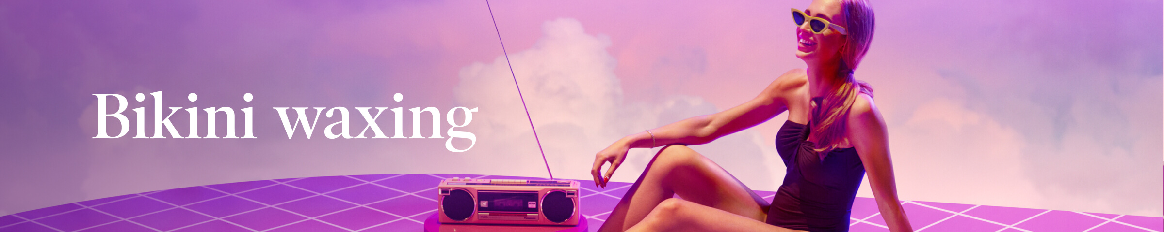 Bikini waxing in white text against purple, pink, and white sky with white woman smiling in black swimsuit and yellow sunglasses lounging on purple checkered surface with old school radio with antenna