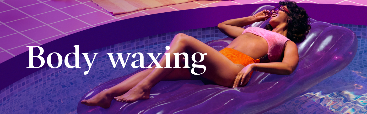 Body waxing in white text juxtaposed over purple pool with woman of color smiling and touching purple sunglasses while lounging on purple float in pink and orange bikini